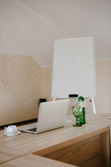 A laptop and a bottle of water on a wooden table