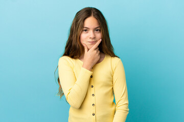 Fototapeta premium Little caucasian girl isolated on blue background thinking