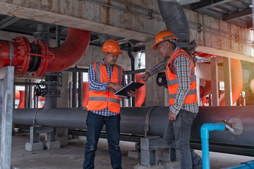 Two worker discuss job in cooling plant.