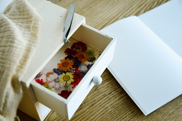 dried flowers in a drawer with a notebook for journaling
