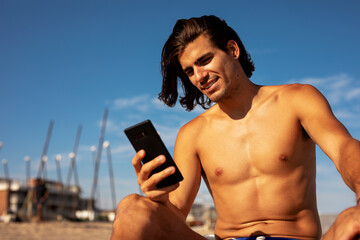 Fototapeta premium Portrait of handsome surfer with his surfboard. Young man with a surfboard on the beach