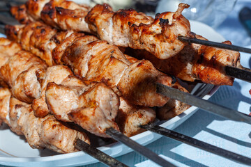 freshly cooked chicken skewers lying in a disposable plastic plate