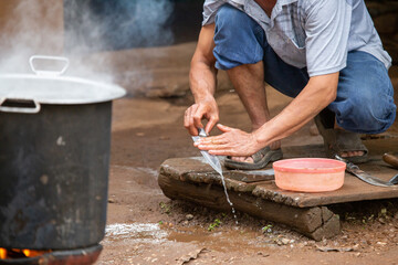 selective focus, hands of rural villagers man raining knife And set up a stove to bring the animals...