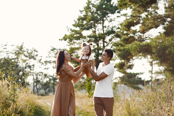 Cute family playing in a autumn field