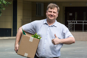 A happy man with a box of personal belongings, a job application