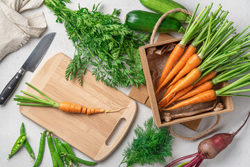 Preparation of fresh vegetables. Carrots, zucchini, peas, beets and greens on a gray background.