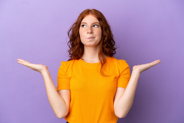 Teenager redhead girl over isolated purple background having doubts while raising hands