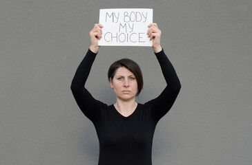 Middle age evropian woman holding a sign with the message My Body My Choice. Feminist protest....
