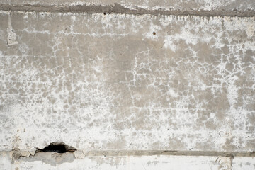 Old grungy grey concrete wall texture with a holes and seams.