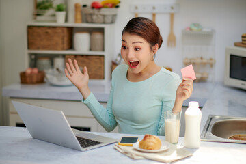 Young asian woman using laptop computer shopping online with credit card buy to internet and...