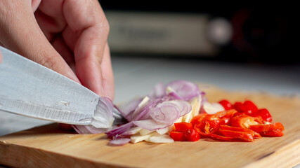 Obraz na płótnie Canvas knife slices onion, garlic and chili on a cutting board