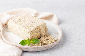 sunflower halva and peanuts on grey plate with mint, napkin