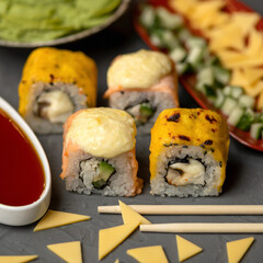Hot grilled Philadelphia roll. Sushi rolls baked with cheese. Chopsticks in foreground. Closeup shot. Soft focus.