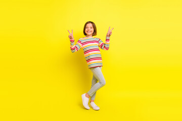 Fototapeta na wymiar Full body photo of happy nice pretty little girl make fingers v-sings cool mood isolated on bright yellow color background