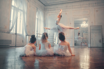 Three little funny ballerinas are looking with delight at gorgeous jump of adult ballerina in...
