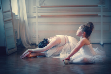 Adult ballerina is teaching a little one. Image with selective focus, noise effect and toning