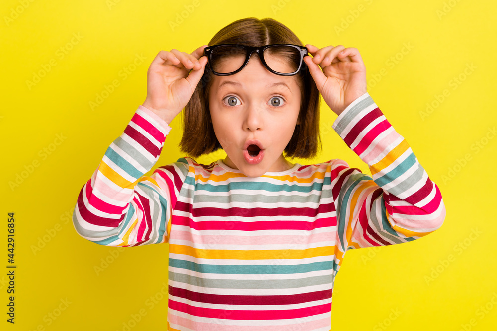 Wall mural photo portrait little girl amazed wearing glasses shocked opened mouth isolated vibrant yellow color