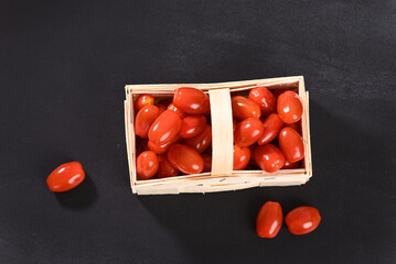 Cherry tomatoes in a wicker basket, top view.