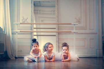Three little ballerinas in the dance class. Image with selective focus, noise effect and toning