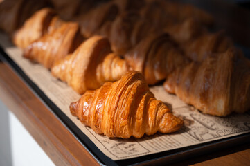 Freshly baked croissants, golden brown on paper, ready to serve in the morning.