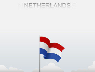 Netherlands flag flying on a pole standing tall under a white sky