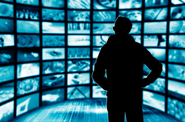 man in a room of many screens, concept for online broadcasting and streaming video