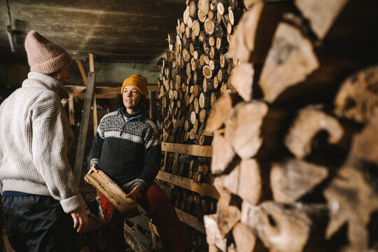 Kvinna plockar ved och pratar med partner