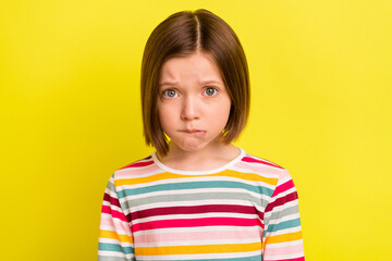 Photo of young unhappy small upset girl bad mood cry face bite lip isolated on shine yellow color...
