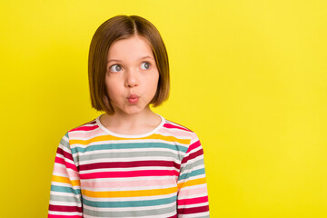 Fototapeta premium Photo of dreamy cute lovely little girl look empty space pouted lips good mood isolated on yellow color background