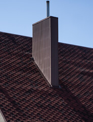 Brown corrugated metal profile roof installed on a modern house. The roof of corrugated sheet. Roofing of metal profile wavy shape. Modern roof made of metal. Metal roofing.