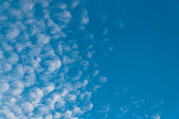 Background and texture of the daytime sky with cirrus clouds at sunrise in the corner of the photo and clear sky for copy space and text.