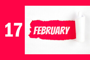 February 17th. Day 17 of month, Calendar date. Red Hole in the white paper with torn sides with...