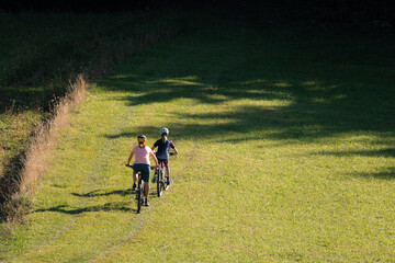 Fototapeta premium Two girls on mtb bikes. Mother and daughter riding on a trail.