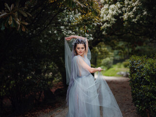 Fototapeta premium a beautiful woman like a fairy or nymph walking in the park