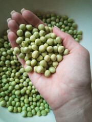 Top view of the hands holding green peas