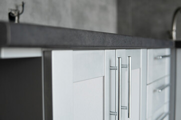 Modern minimalist style kitchen close up in monochrome tones. Custom kitchen with grey white...
