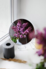 Reflection composition of lilac flowers and mirror. Minimalism decor.