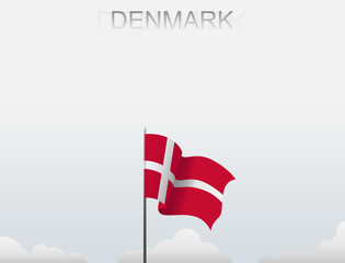 Denmark flag flutters on a pole standing tall under a white sky