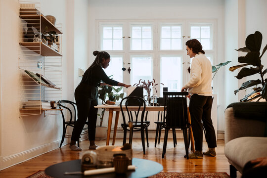 Aff&auml;rskvinna och aff&auml;rsman st&aring;r vid bord p&aring; hemmakontor