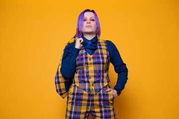 young woman with purple hair in a stylish bright plaid suit.