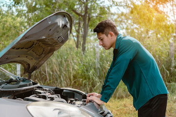 Man open car hood for repair as maintenance service. Man trying to check a car engine, looking...