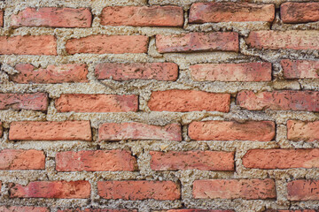 Red brick wall constructed using cement to connect