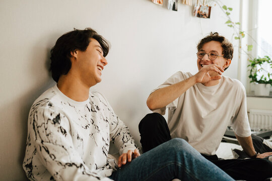 Glad man med glas&ouml;gon pratar med kompis sittande hemma