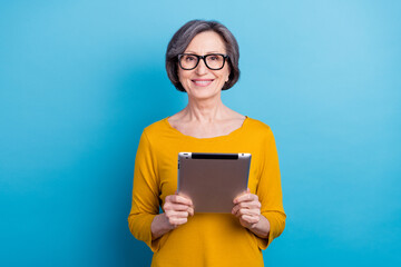 Portrait of attractive cheerful woman holding in hands using device gadget web search isolated over...
