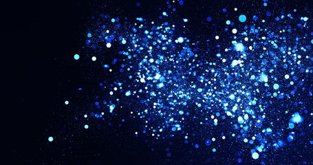 Illuminated blue and white particles floating on a black background