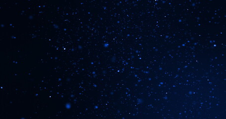 Fototapeta premium Defocussed blue particles rotating on a black background