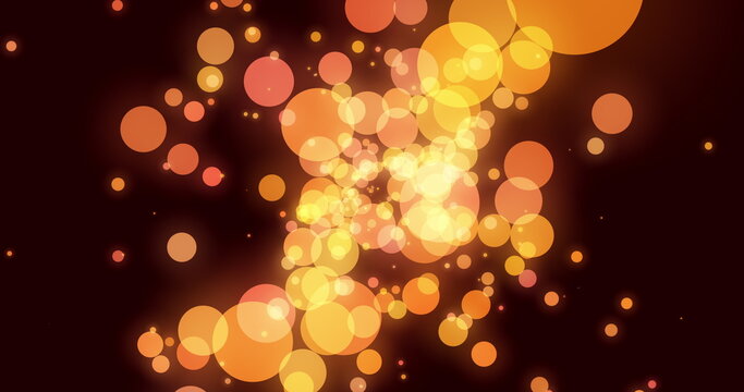 Orange and yellow glowing translucent circles effervescing on a dark background