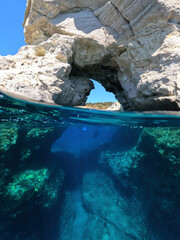 Underwater sea level split photo of underwater white chalk volcanic cave with emerald crystal clear...