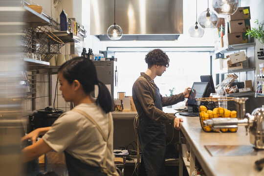 Kollegor arbetar bakom kassa i matbutik