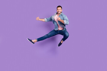 Fototapeta na wymiar Full length body size photo man smiling jumping up on karate training isolated pastel violet color background